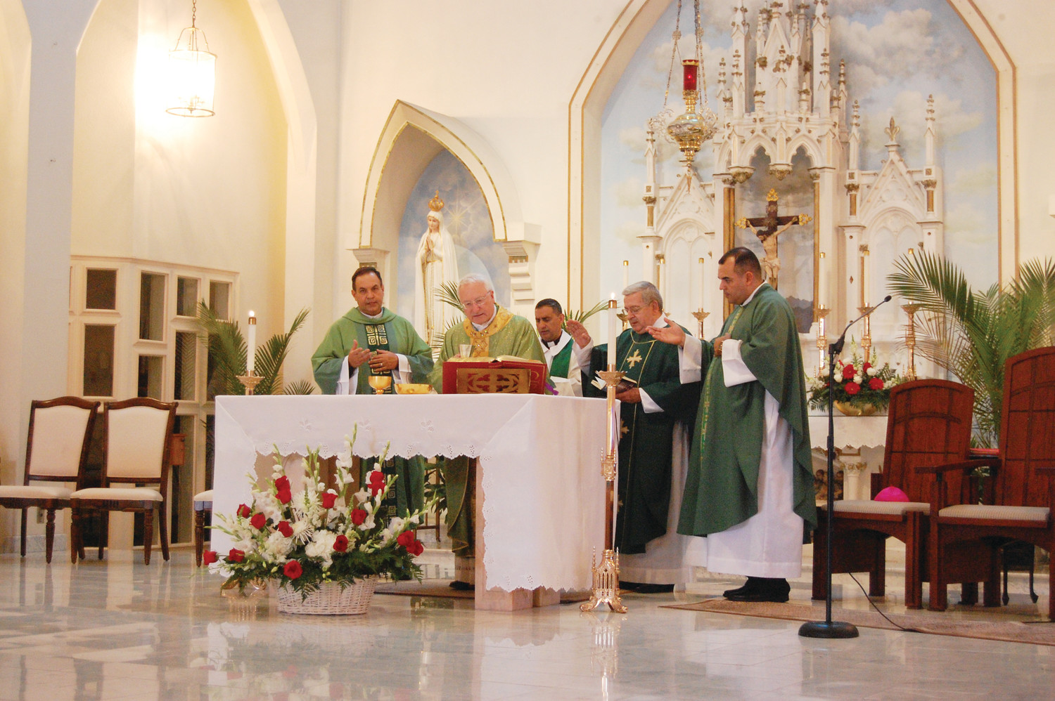 Father Marinald Batista, C.S.P., the new pastor at St. Elizabeth’s Church in Bristol, at left, concelebrates his installation Mass with Auxiliary Bishop Robert Evans, center.